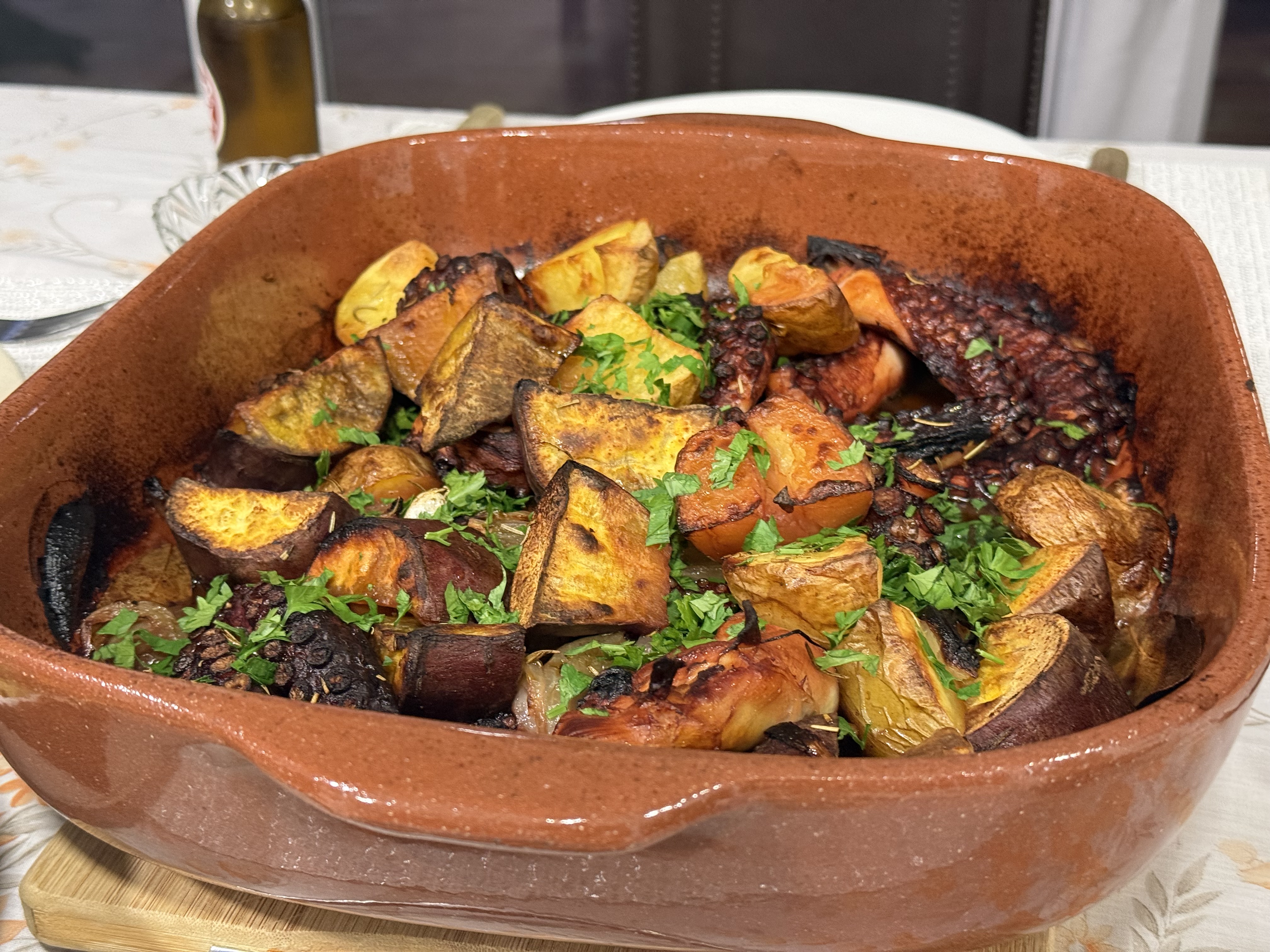 Oven-roasted octopus with sweet potatoes in a clay dish