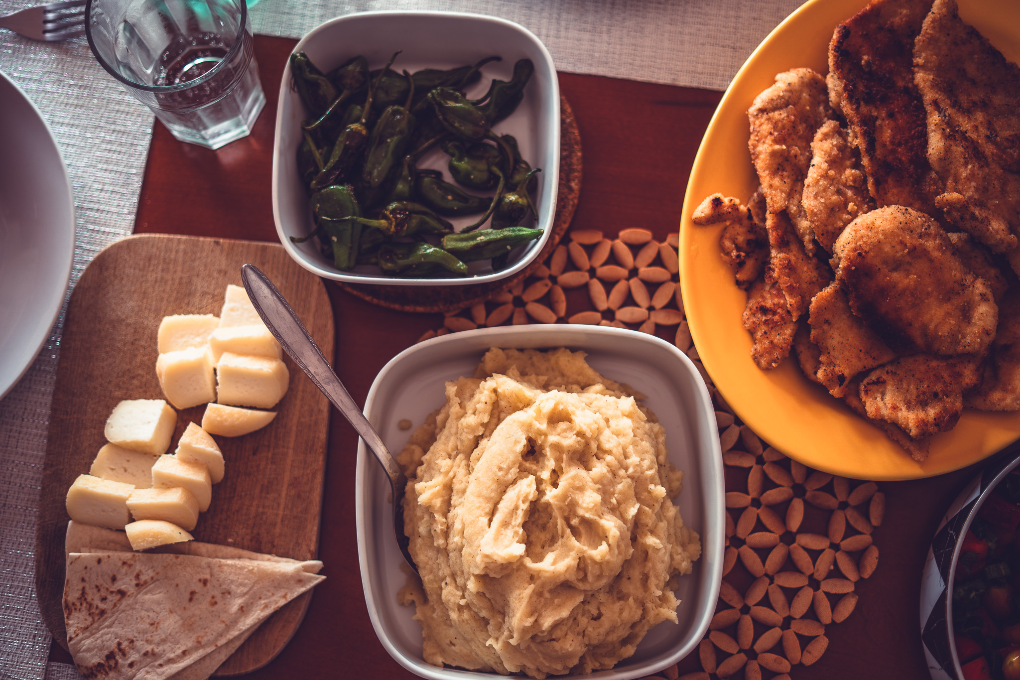 Table laid with homemade dishes — peppers, cheese, bread and garden vegetables