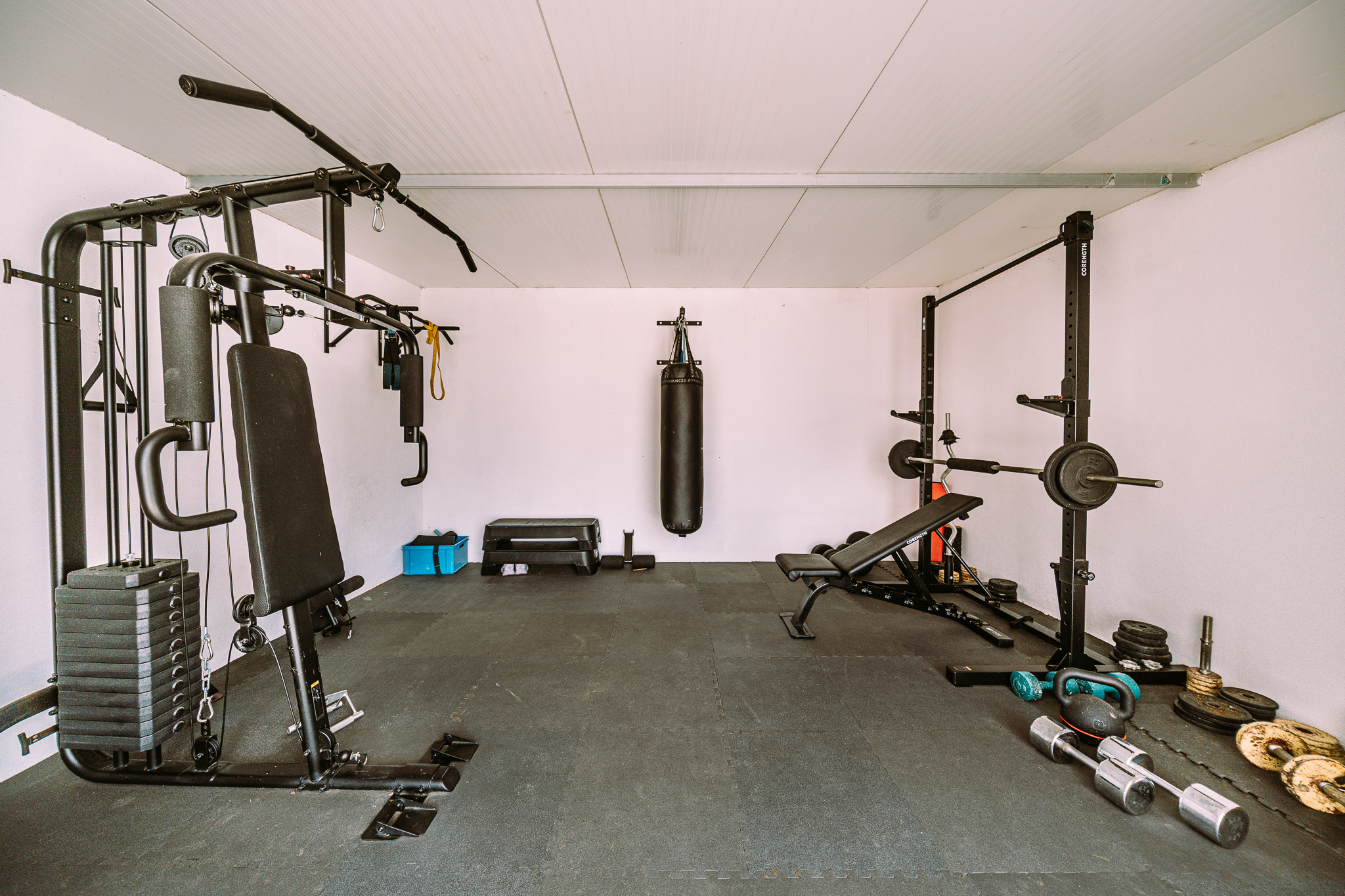 The private on-site gym — multi-gym, punch bag, squat rack and free weights