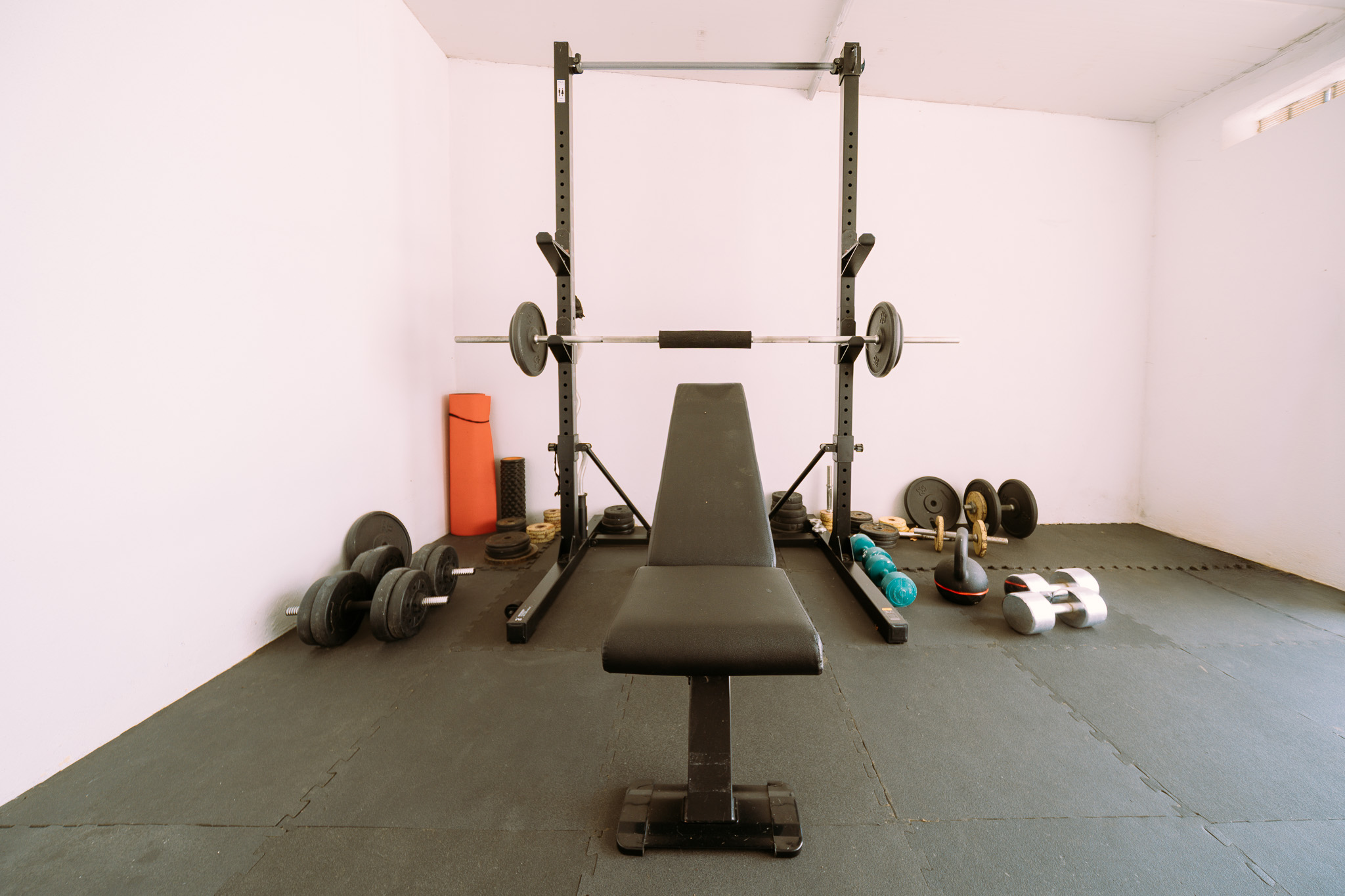 Squat rack with barbell and adjustable bench