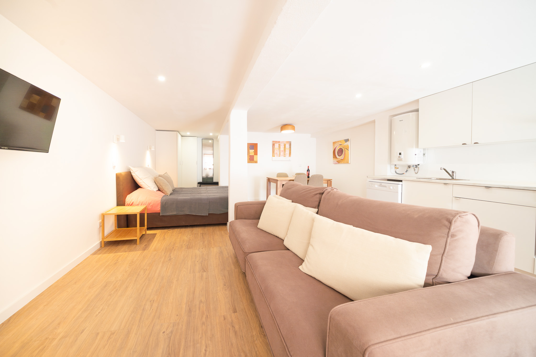 The Studio — open-plan room with sofa, double bed, dining table and kitchen