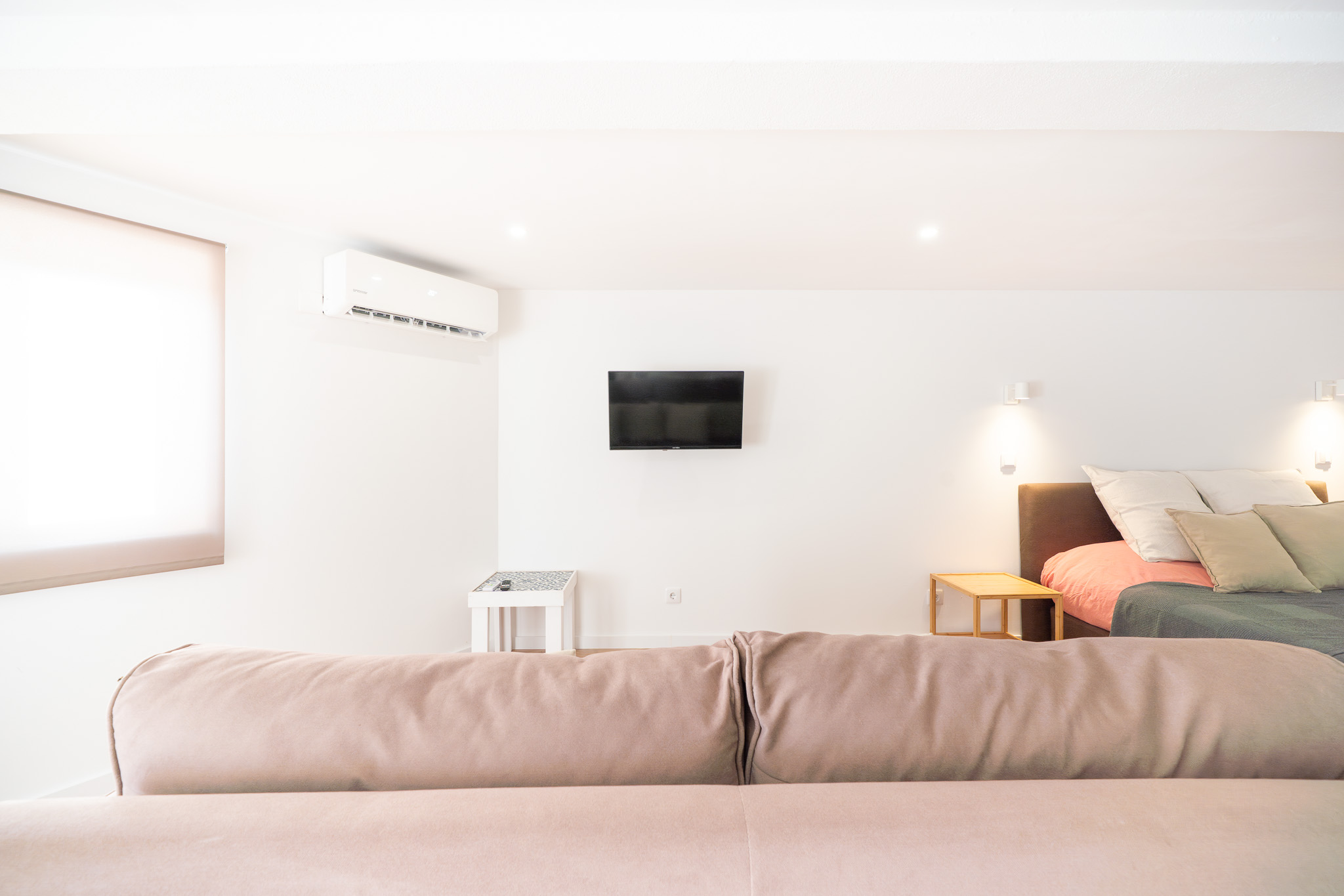 Studio sofa facing the TV, air conditioning and bed