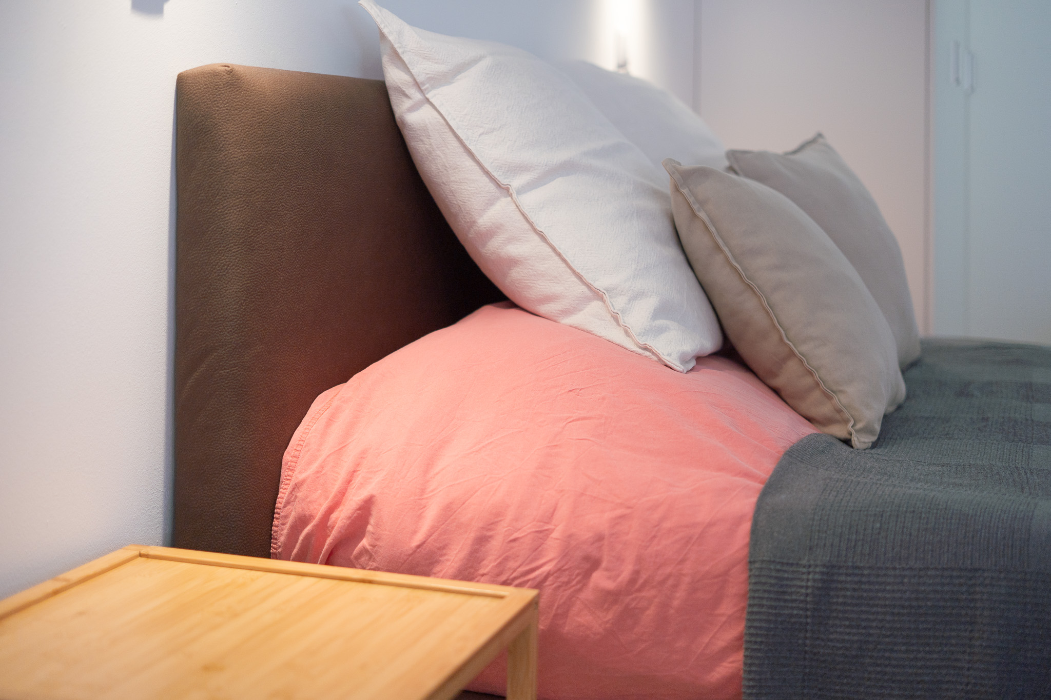 Studio bed with soft pillows and bedside table