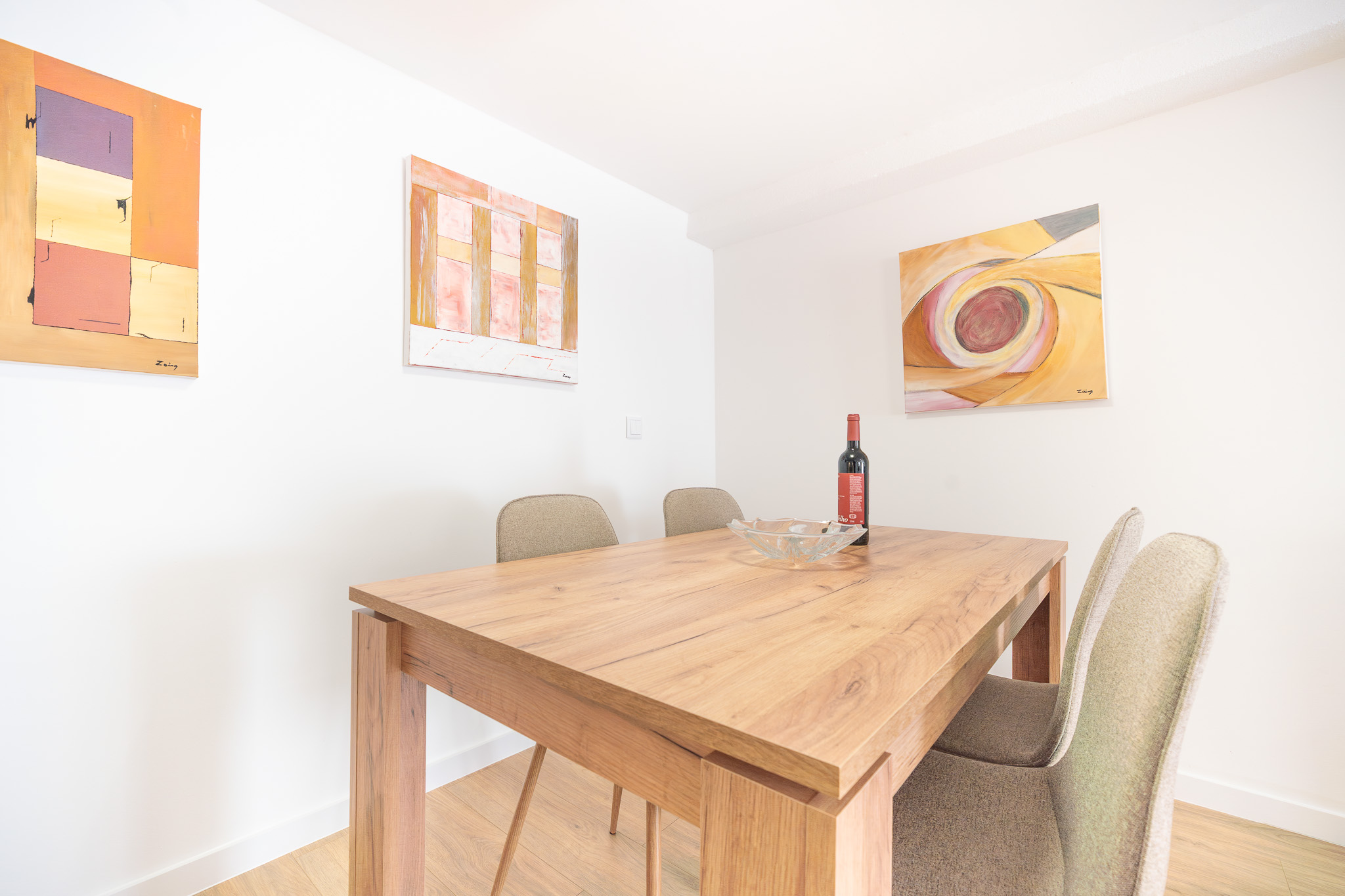 Studio dining table for four with paintings on the wall