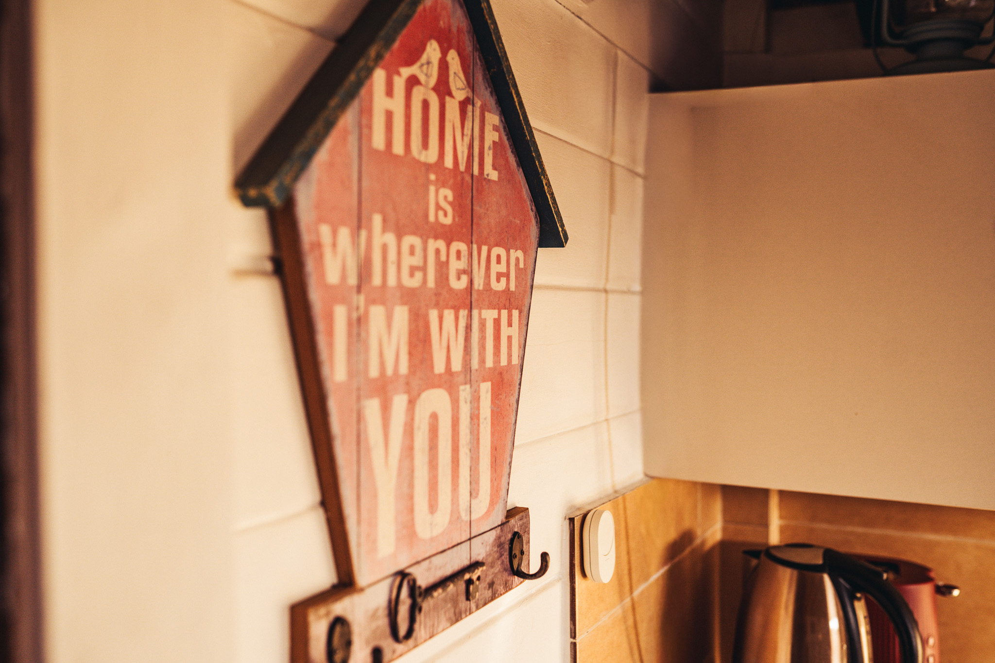 Sign in the cabin reading home is wherever I am with you
